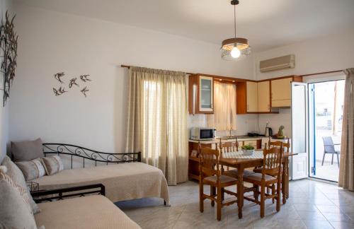 a living room with a bed and a kitchen at Sunrise Studios in Megalochori