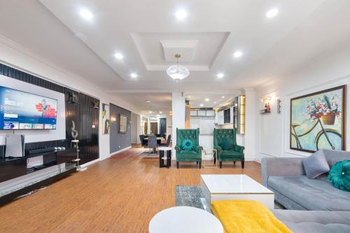 a living room with a couch and chairs and a tv at WATER VIEW 3 BEDROOM APARTMENT WITH JACUZZI PARKING WiFi NETFLIX POOL in Lekki