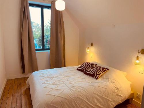 une chambre avec un lit avec un oreiller dessus dans l'établissement Maison Yodée, à Cancale