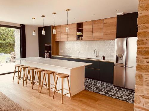 une cuisine avec un grand îlot et des tabourets de bar dans l'établissement Maison Yodée, à Cancale