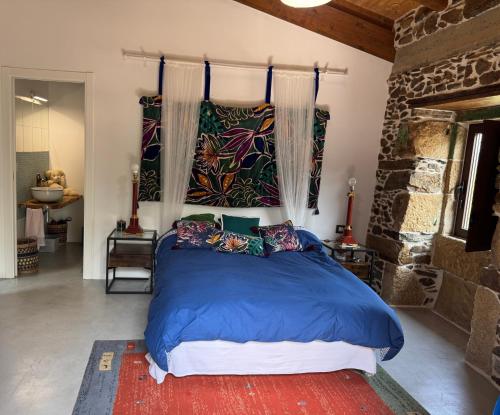 una camera da letto con un grande letto con lenzuola e cuscini blu di Casa Vella do Nanín a Faramontaos
