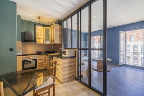 - une cuisine avec des placards en bois et des parois en verre dans l'établissement Les Docs, 2 chambres emplacement exceptionnel, à Marseille