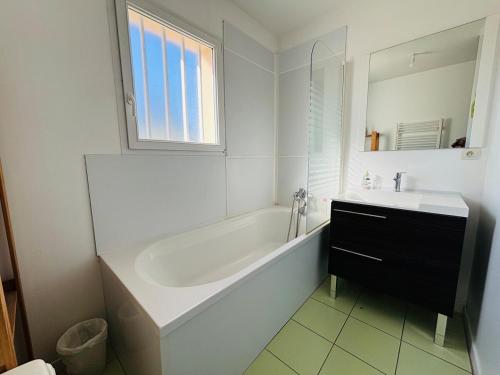 une salle de bain blanche avec une baignoire et un lavabo dans l'établissement Beautiful home near Honfleur Deauville, à Beuzeville