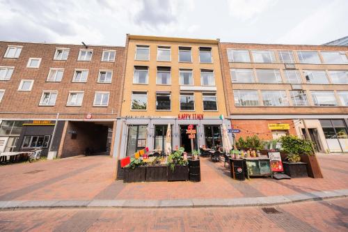 a building on a street with flowers in front of it at Alphabet Apartments - Binnenrotte 102 in Rotterdam