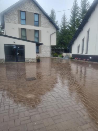 a rain soaked courtyard with a building in the background at Chalet Solaris in Buşteni