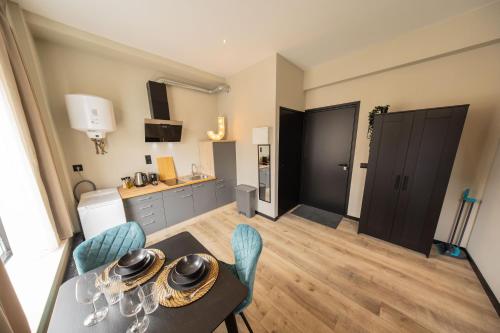 a living room with a table and chairs and a kitchen at Alphabet Apartments - Binnenrotte 102 in Rotterdam