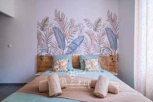 een slaapkamer met een groot bed en een muurschildering bij Douceur bucolique, jardin & mezzanine cosy in Parigné-lʼÉvêque