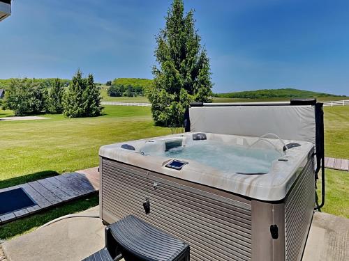 a hot tub sitting on a patio with a chair at Dacha Verde in Swanton