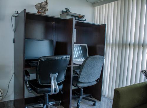 an office with two chairs and a desk with a computer at Ramada by Wyndham Medicine Hat in Medicine Hat