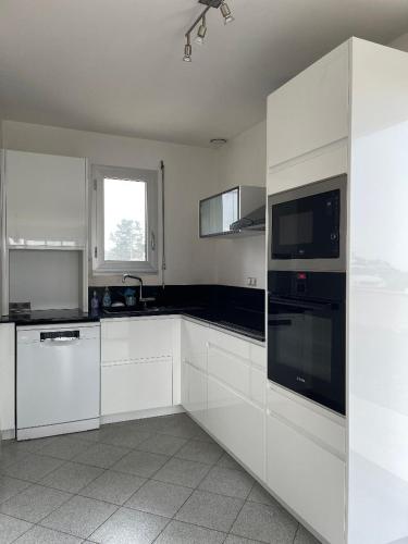 une cuisine blanche avec des armoires blanches et une fenêtre dans l'établissement HolidayVilla50mFromBeach VillaDeVacancesPlage à50m, à Saint-Pair-sur-Mer