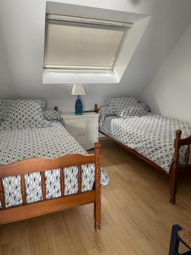 une chambre avec deux lits et une lampe sur une table dans l'établissement HolidayVilla50mFromBeach VillaDeVacancesPlage à50m, à Saint-Pair-sur-Mer