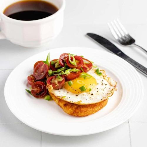 a plate of food with a fried egg and a cup of coffee at Arusha Hideway Resort in Old Moshi