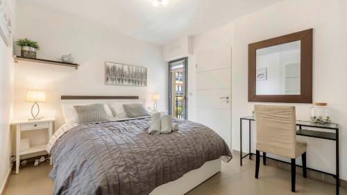 une chambre avec un lit, un bureau et un miroir dans l'établissement Le Riviera 3 bed apartment Sainte Maxime, à Sainte-Maxime