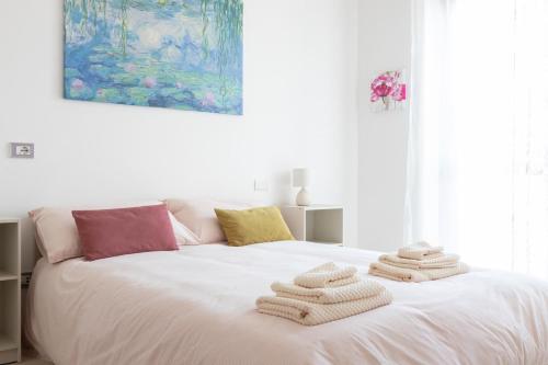 a white bed with towels on top of it at Suite Moderna 60 m2 con terrazzo privato - 5 min da Aeroporto FCO e Fiera di Roma in Fiumicino Airport