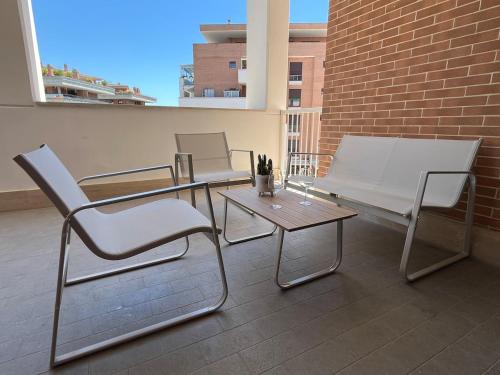 two chairs and a table on a balcony at Suite Moderna 60 m2 con terrazzo privato - 5 min da Aeroporto FCO e Fiera di Roma in Fiumicino Airport