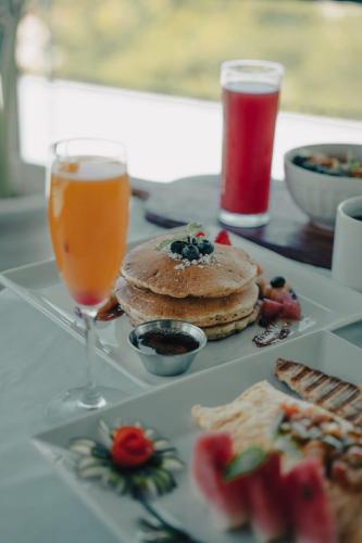 een tafel met een bord eten en een glas sap bij Hill Garden Resort Hotel in San Ignacio