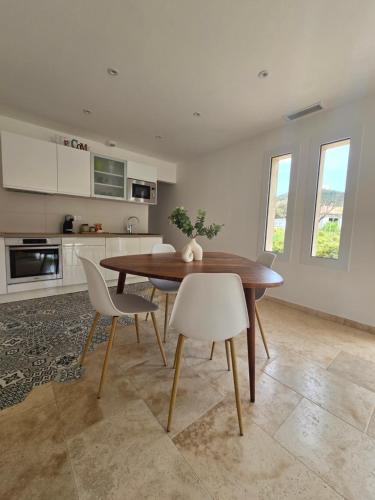 une cuisine et une salle à manger avec une table et des chaises en bois dans l'établissement Domaine U Filanciu - Casa Ghjulia - Centru di Corsica, à Moltifao