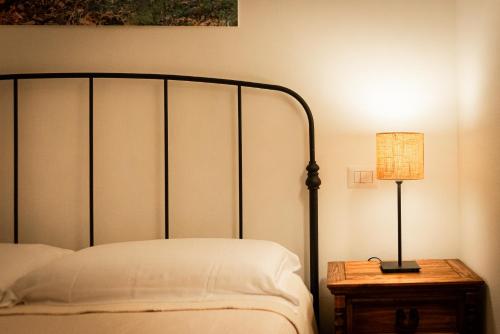 a bedroom with a bed and a lamp on a table at AGRITURISMO 8e28 CAPALBIO in Nunziatella