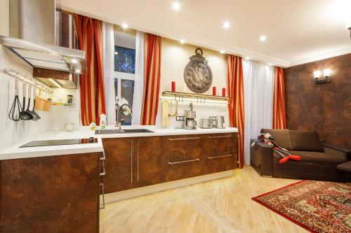 uma cozinha com um lavatório e um sofá num quarto em BridgeStoneLuxApart Free Parking em Riga