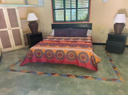 a bedroom with a large bed and two lamps at Villa à 250 mètres de la Mer in Las Terrenas