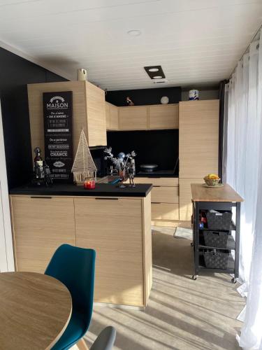 une cuisine avec des armoires en bois et une table et des chaises dans l'établissement Cottage Cap d'Agde, à Agde