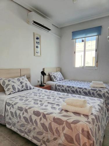 a bedroom with two beds and a window at Enjoy Sevilla in Seville
