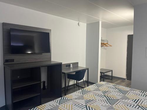 a room with a bed and a desk with a television at Motel 6 Chicago, IL - Halsted in Chicago