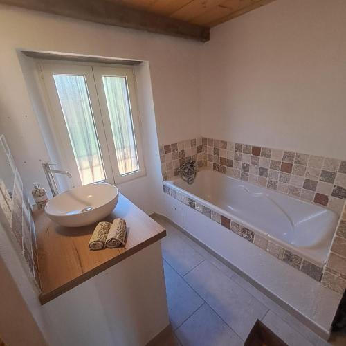 une salle de bain avec une baignoire, des toilettes et un lavabo dans l'établissement A Casuccia - Maison traditionnelle Corse avec piscine privée, à San-Nicolao