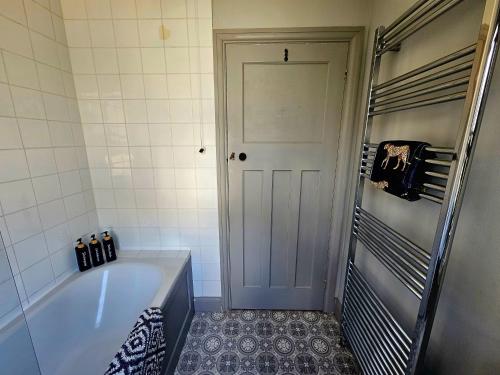 a small bathroom with a tub and a shower at Prospect Cottage in Hythe