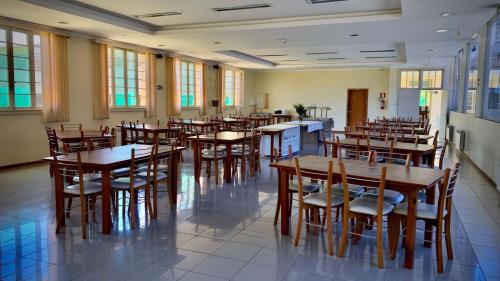 a dining room with wooden tables and chairs at Hotel Murialdo in Caxias do Sul