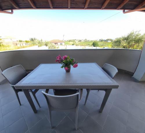 a table with a vase of flowers on a balcony at Villa VVG in Koxhas