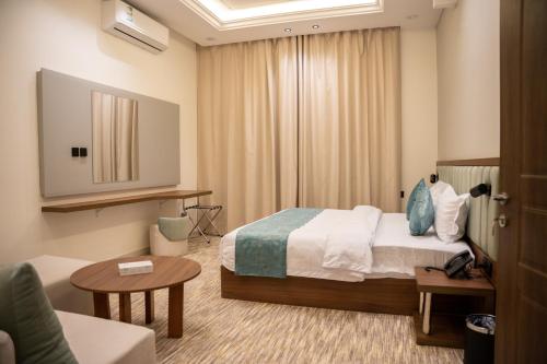 a hotel room with a bed and a couch at الان للشقق المخدومة in Hail
