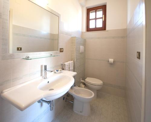 a bathroom with a sink and a toilet and a mirror at Antica Melegnano in Atri