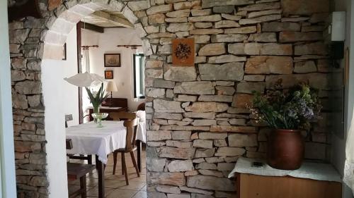 a room with a table and a stone wall at House Darin dvor in Vela Luka