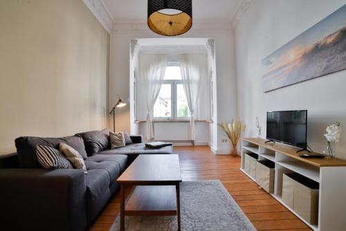 a living room with a couch and a tv at Altbauoase im Goethequartier in Bremerhaven