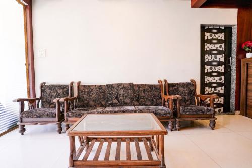 a living room with a couch and two chairs and a table at SPOT ON Jahanvi Guest House in Neral