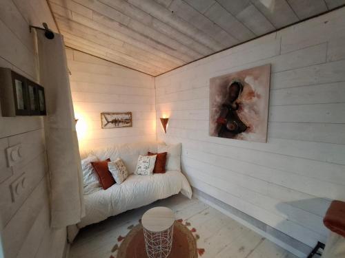 a white room with a couch in a wall at La cabane zen in Saint-Martin-des-Champs