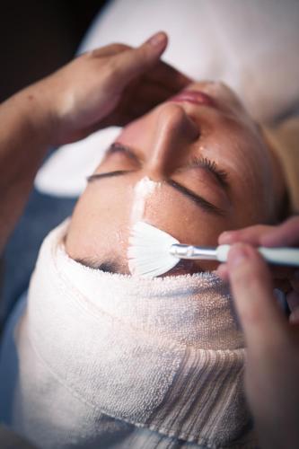 a woman getting her face brushed with a brush at Hotel Hirschenstein in Achslach