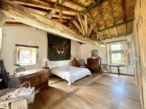 une chambre avec un lit dans une pièce avec des plafonds en bois dans l'établissement Logis de la Vau - Private pool - Quiet, à Saint-Benoist-sur-Mer