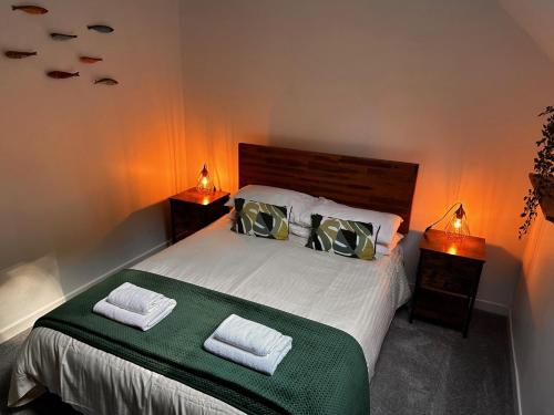 a bedroom with a large bed with two night stands at 51 Fernhill Heights in Bridport