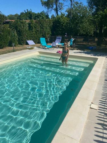 un jeune garçon debout dans une piscine dans l'établissement Logis de la Vau - Private pool - Quiet, à Saint-Benoist-sur-Mer
