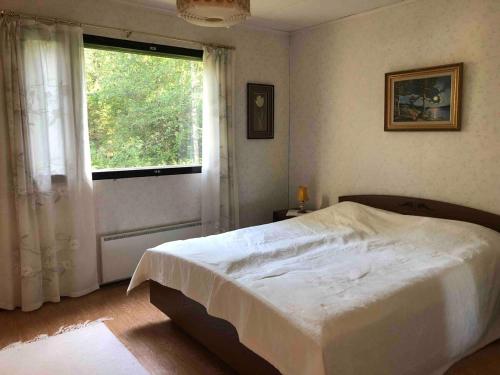 a bedroom with a large bed and a window at Purola holiday cottage by the lake Kivijärvi in Kivijärvi