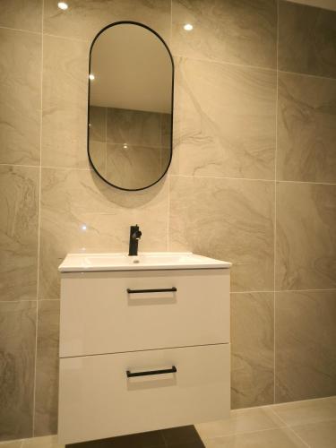 une salle de bain avec un lavabo blanc et un miroir dans l'établissement Appartement castellane, à Marseille