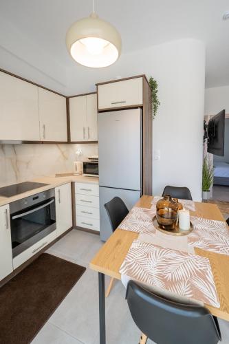 a kitchen with a table with chairs and a refrigerator at Kyma Luxury Home in Pogoniá