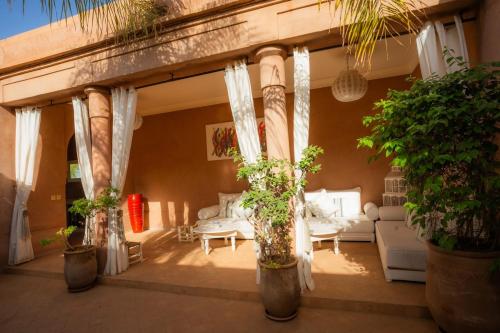 a living room with potted plants and a couch at Luxueuse villa VALERIA avec gouvernante in Chaibate