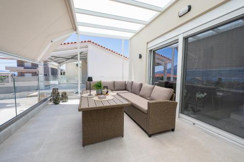 a living room with a couch and a table at Kyma Luxury Home in Pogoniá