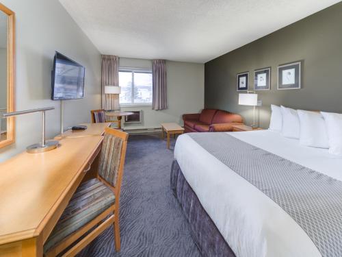 a hotel room with a bed and a desk at Heritage Inn Hotel & Convention Centre - Cranbrook in Cranbrook