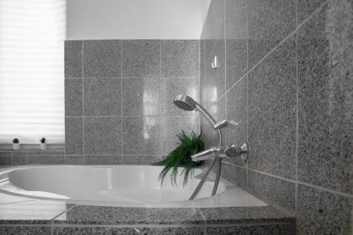 a bath tub with a faucet in a bathroom at Altbauoase im Goethequartier in Bremerhaven