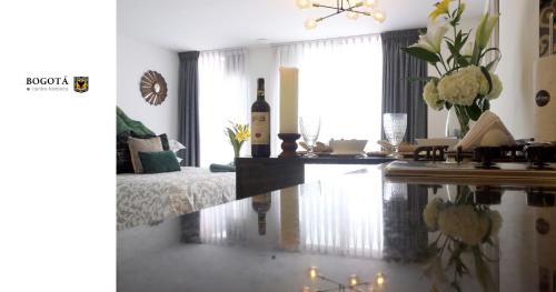 a living room with a table with a bottle of wine at MONTFORT Suite Royale Stylish Location with View to Bogotá's historical Church in Bogotá