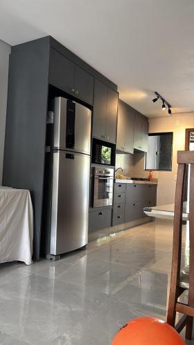 a kitchen with a stainless steel refrigerator and cabinets at Casa Joinville in Joinville